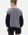 A casual yet stylish dropped-shoulder gray sweater complements the chic black shirt