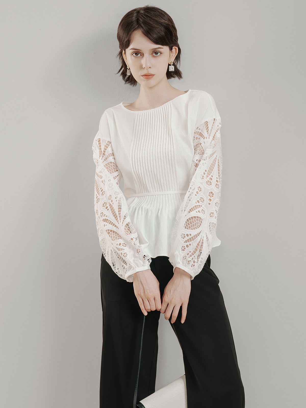 Women&#39;s long-sleeve peplum top with delicate lace cutout accents