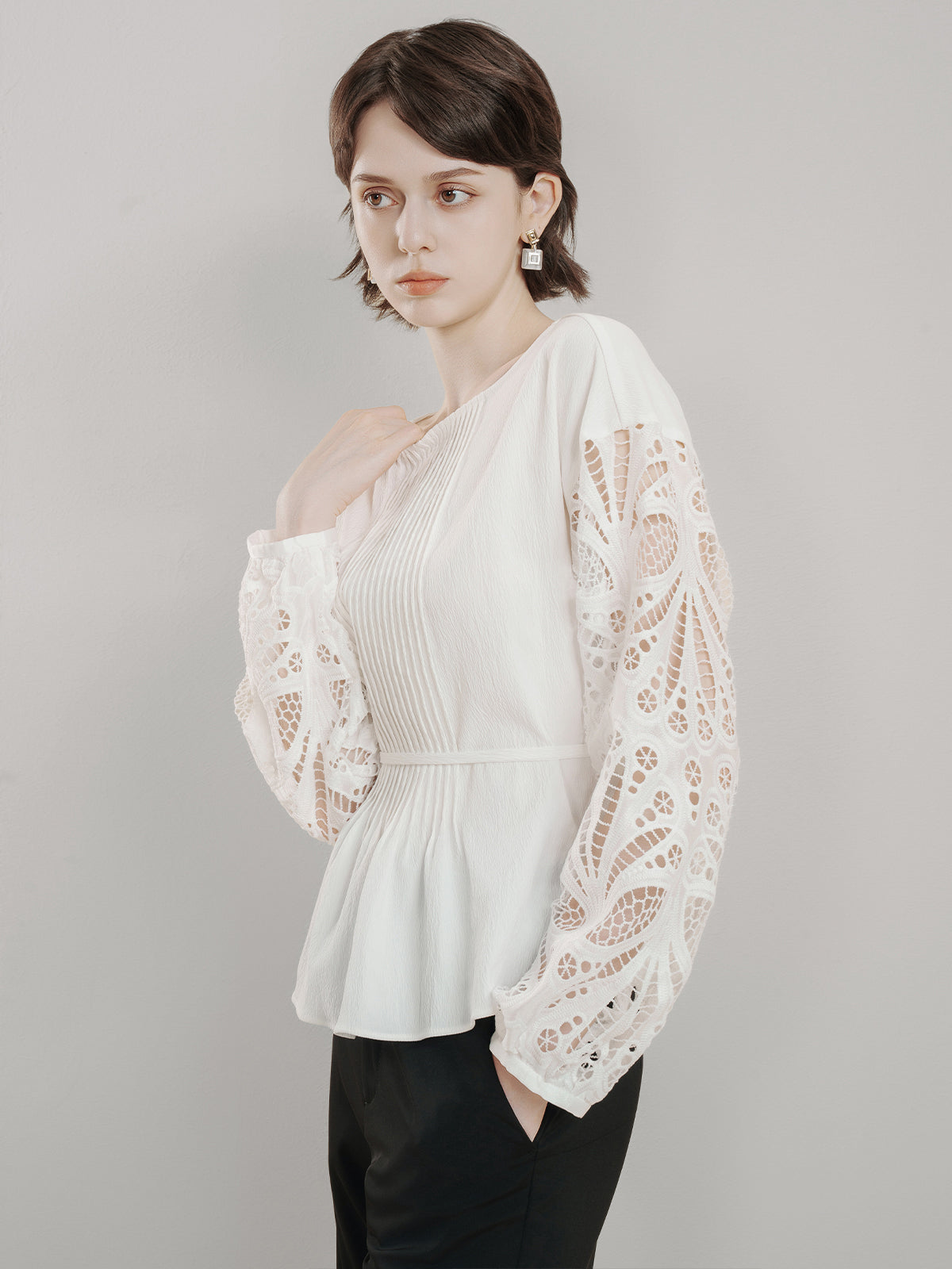 Romantic boho-style blouse with intricate lace sleeves and pleated front