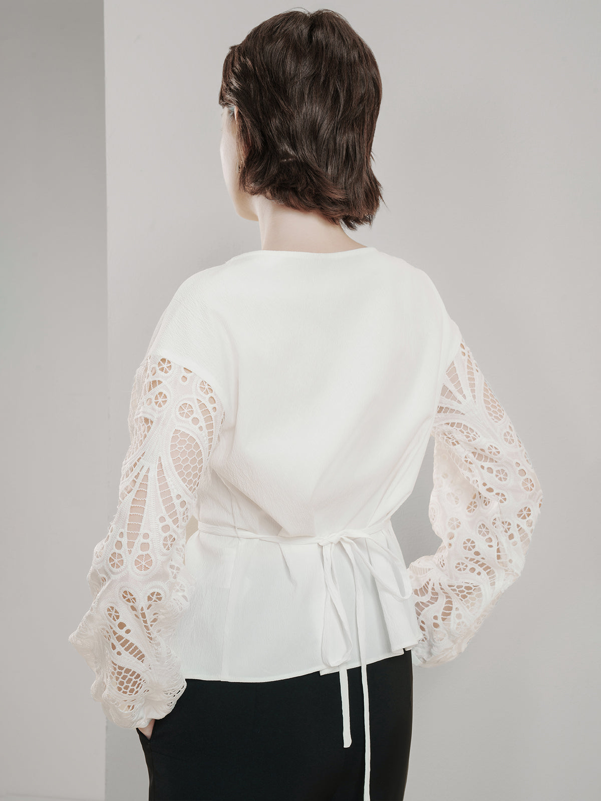 Chic white top featuring sheer lace balloon sleeves and a cinched waist