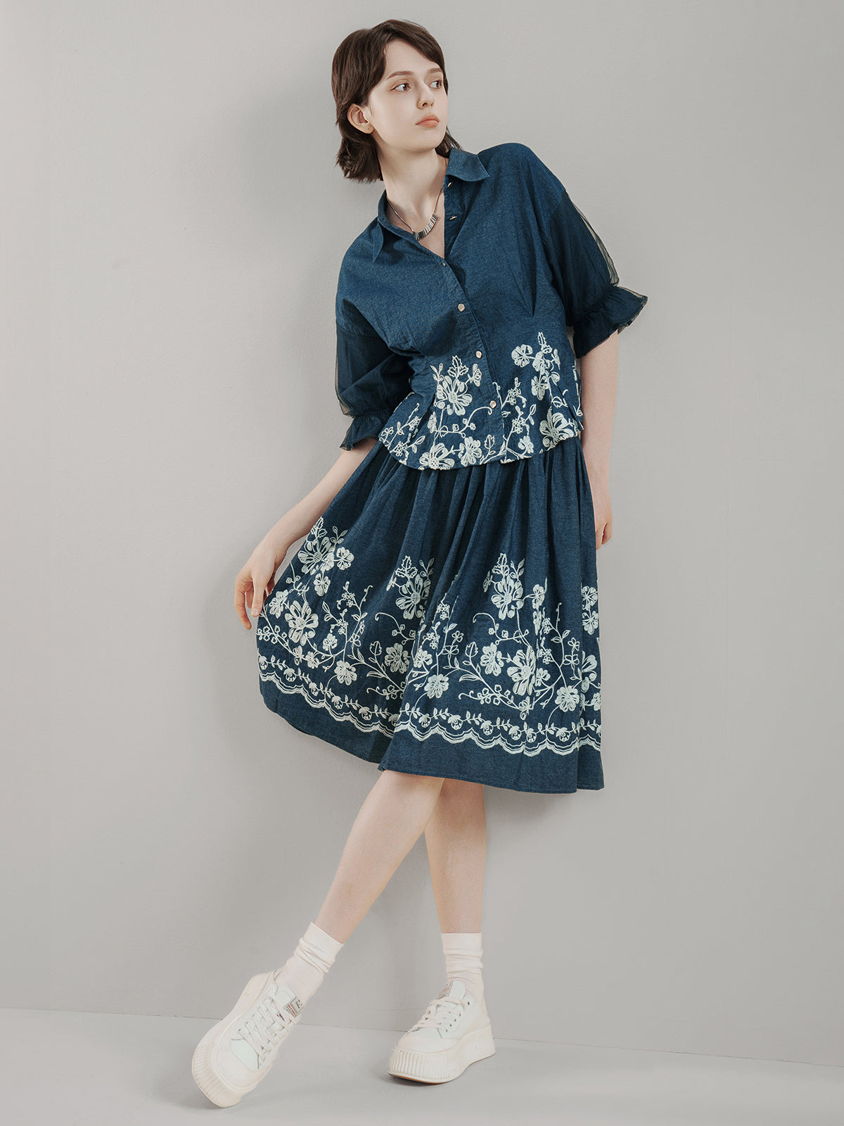 Dark blue cotton midi skirt with delicate white floral embroidery, high-waisted design, and flared A-line silhouette, offering breathable comfort and vintage charm for summer outfits
