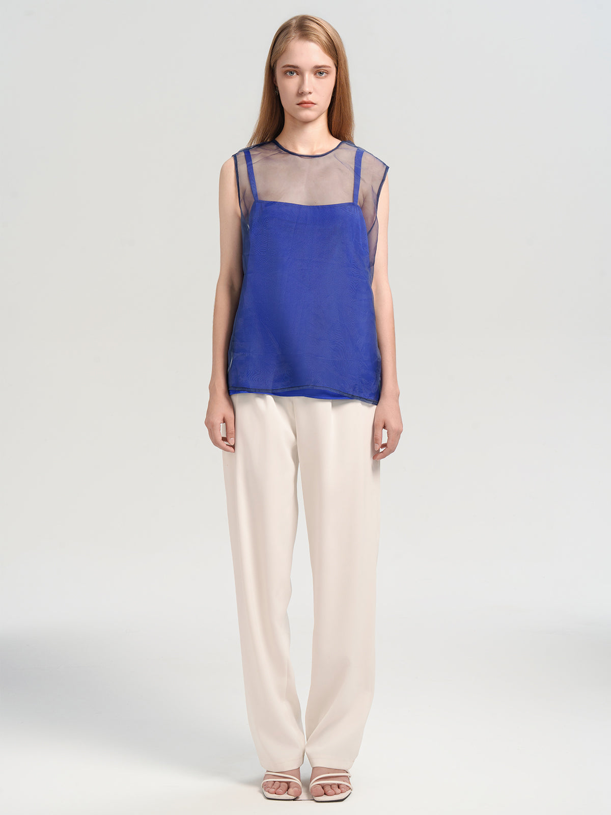 Women&#39;s blue sleeveless top with sheer mesh overlay and layered camisole design