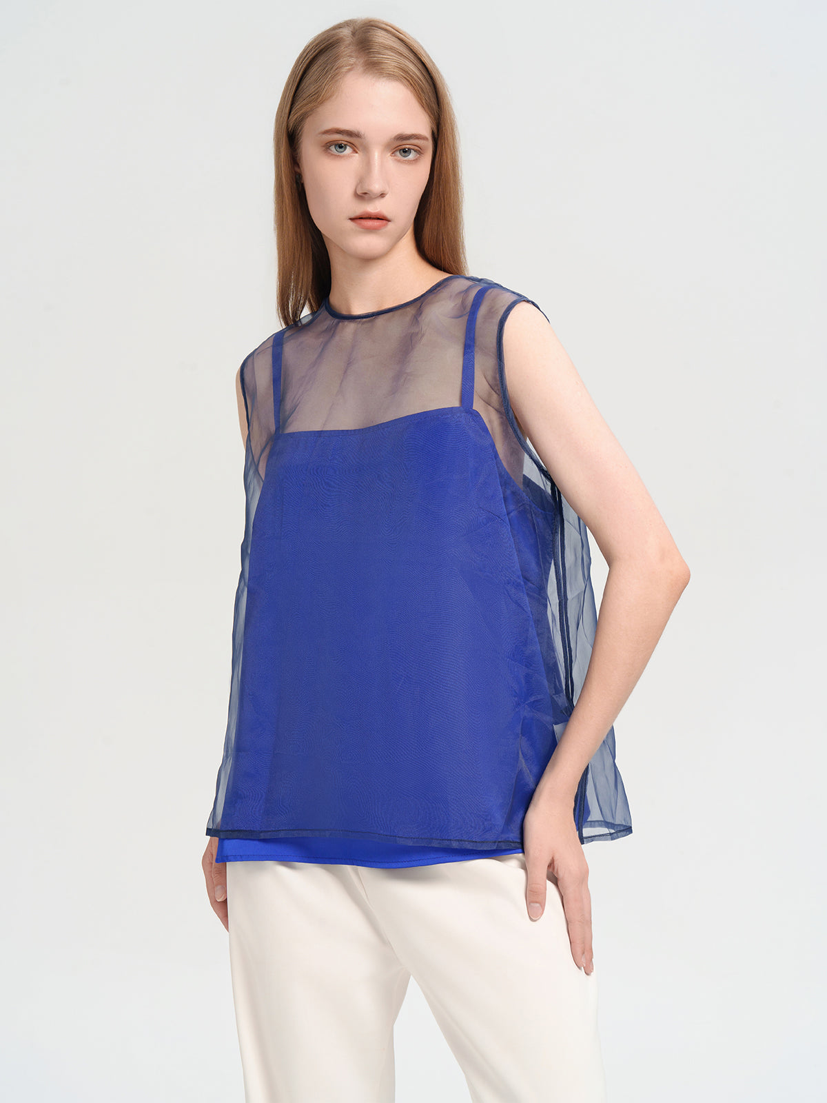 Elegant blue and sheer mesh sleeveless top, perfect for contemporary fashion styling