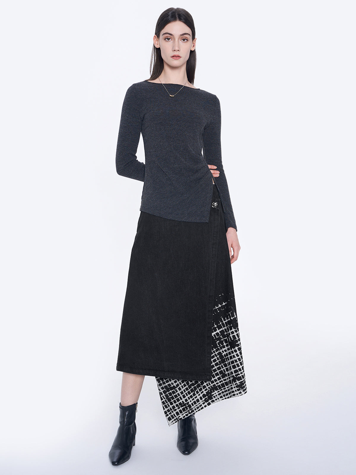 Black wrap skirt with geometric white print on the hem, featuring a side button detail and modern design