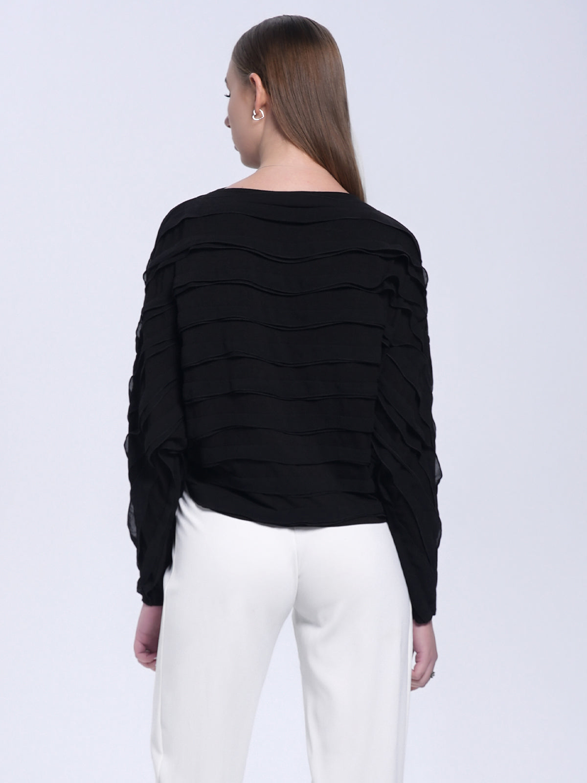 Black textured long-sleeve blouse with wavy layered design, loose fit, and modern minimalist style