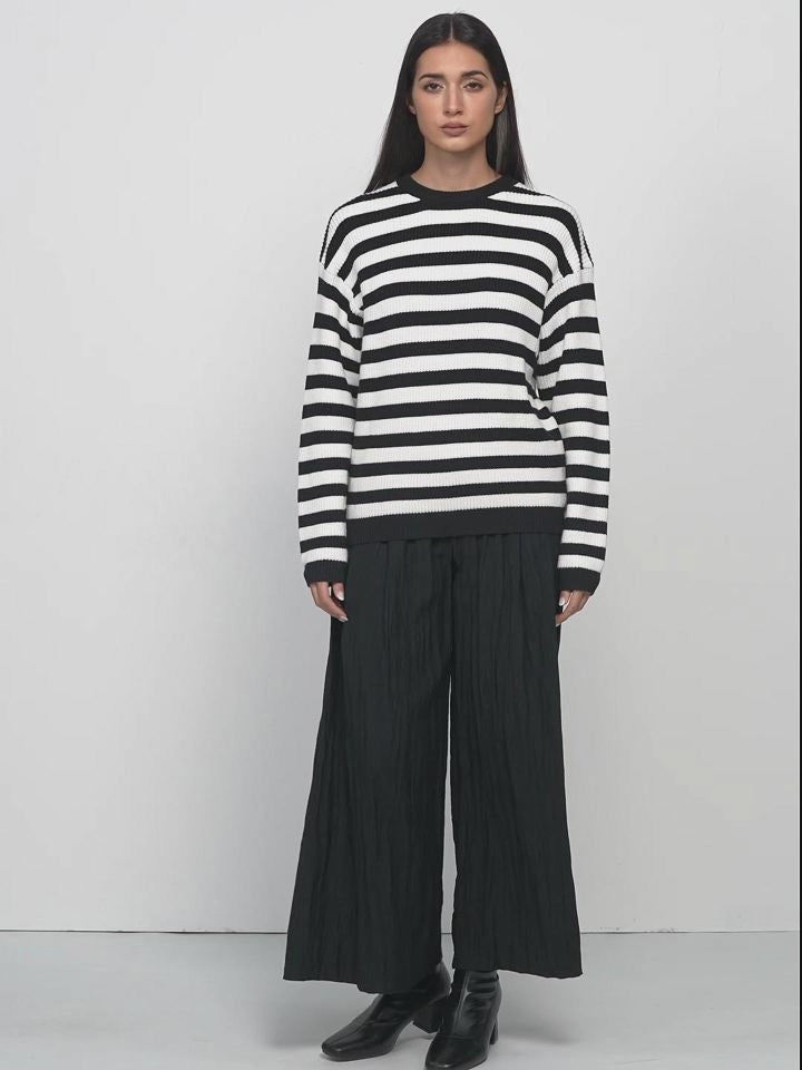  This ribbed sweater with a round neckline offers a versatile and comfortable wardrobe essential, perfect for various occasions with its classic black and white stripes.